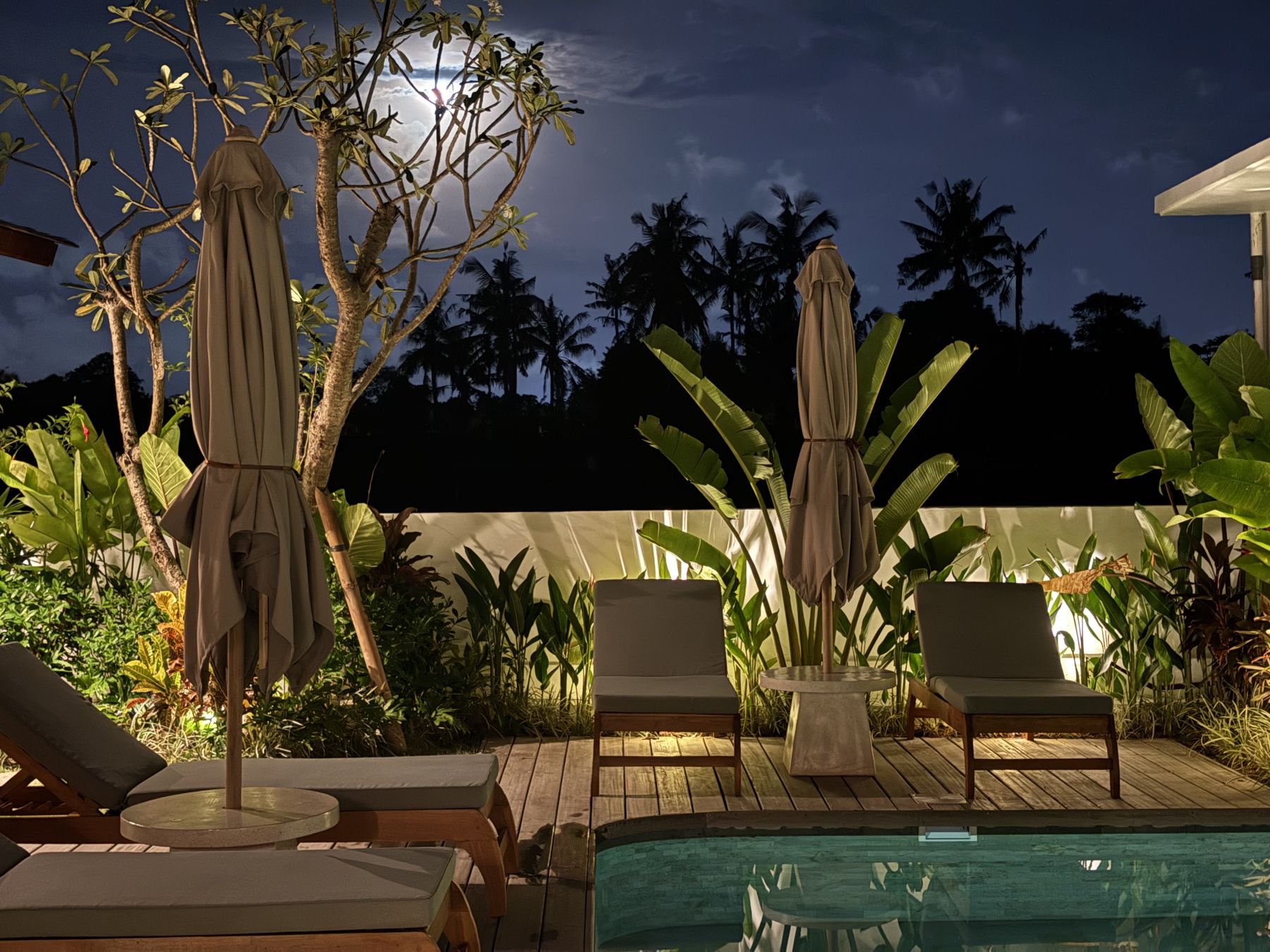 Pool and loungers lit at night